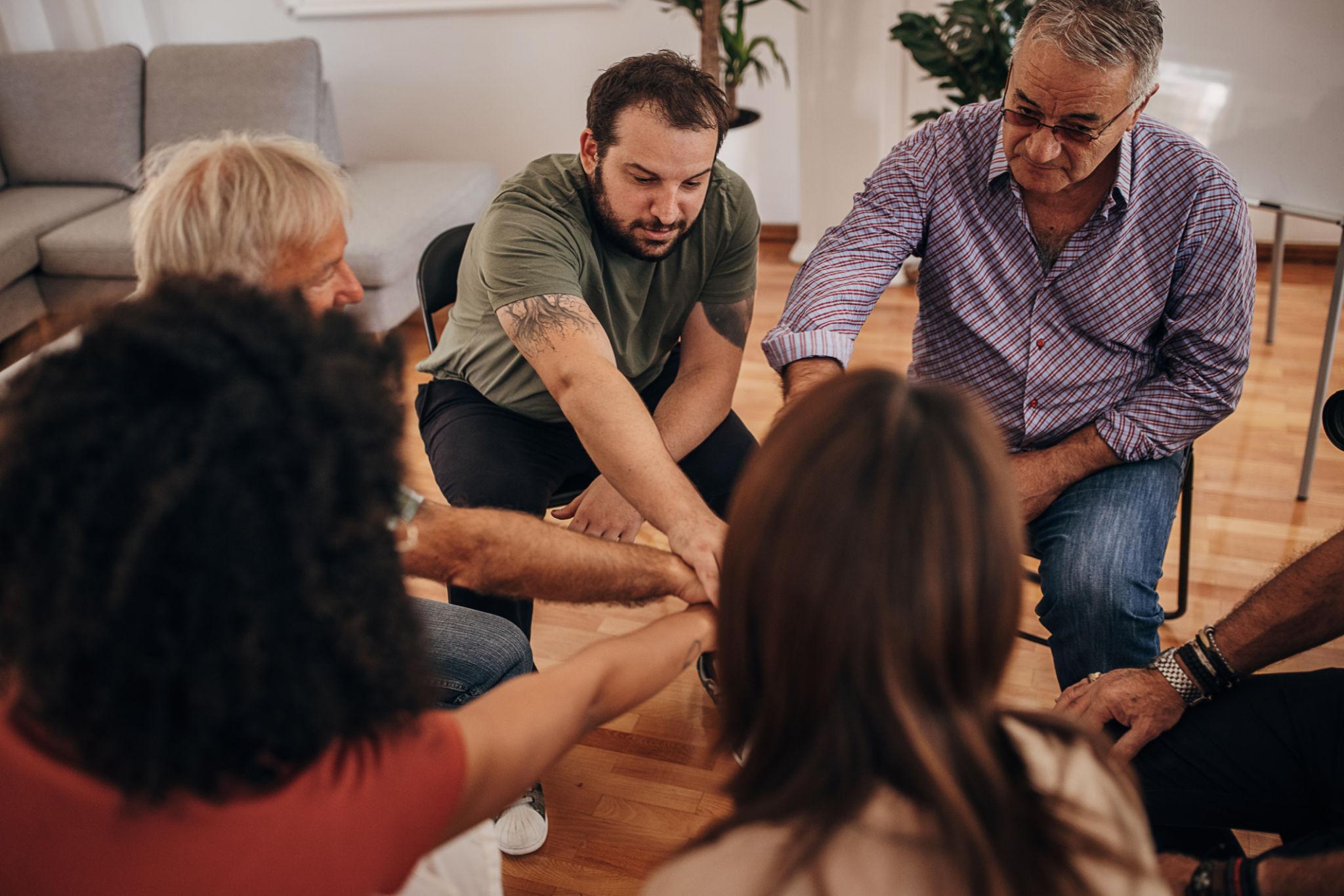 addiction recovery support group people sitting in circle sharing and healing